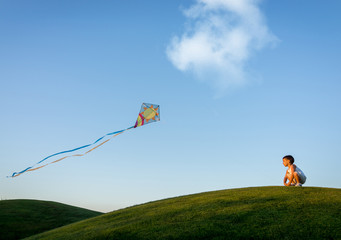 Little boy on summer vacation having fun and happy time flying k