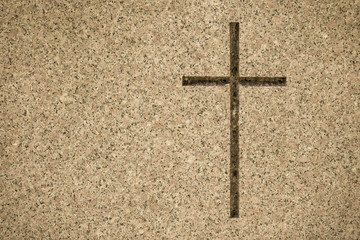Detail of cross on tombstone in cemetery. Engraving with christian religious symbol in close up...