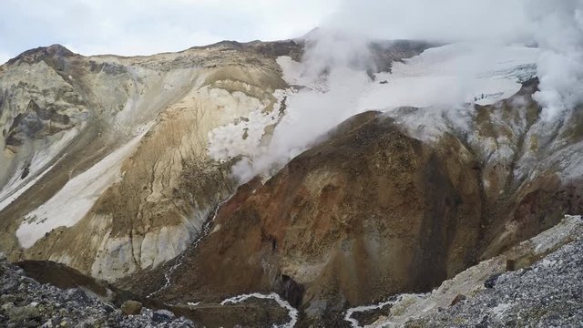 Active volcano of Kamchatka Peninsula: thermal, fumarole field in crater of Mutnovsky Volcano - view of the eruption of gas and steam from fumaroles. Eurasia, Russian Far East, Kamchatka Region.