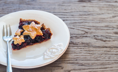 Portion of mince pie on the wooden background