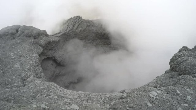 Volcanic activity on Kamchatka Peninsula - view of boiling thermal mud pot in the crater of active Mutnovsky Volcano. Eurasia, Russian Far East, Kamchatka Region.