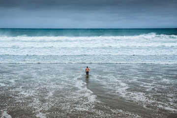 Lonely man entering the water at overcast beach.

Loneliness is a complex emotion who response to isolation. Overcast is the meteorological condition of clouds obscuring all of the sky. 