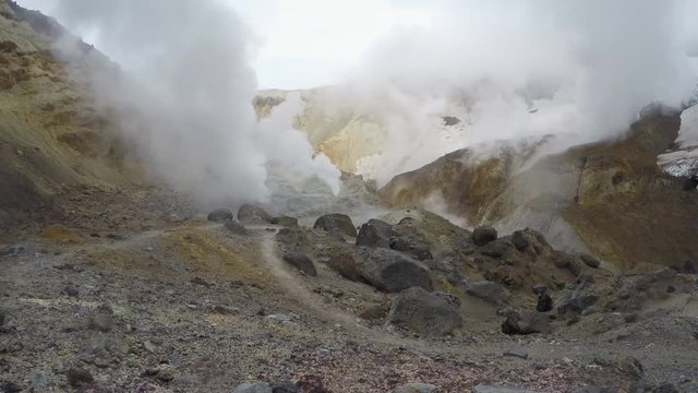 Volcanic landscape on Kamchatka Peninsula: thermal, fumarole field in crater of active Mutnovsky Volcano: view of the eruption of gas and steam from fumaroles. Russian Far East. (Time-lapse, 4K)