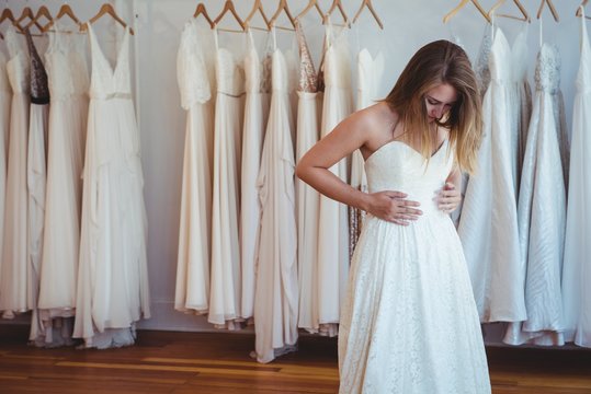 Beautiful woman trying on wedding dress in a shop