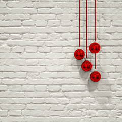 Christbaumkugeln vor weissem Mauerwerk