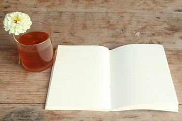 Hot tea, flower and blank note page.on wood table.