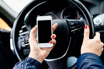 Woman holding a white smartphone with blank screen