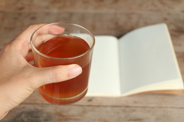 Hot tea and blank note page.on wood table.