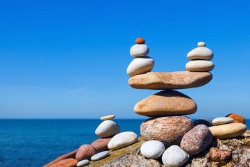 Concept of harmony and balance. Balance and poise stones against the sea. Rock zen in the form of scales