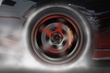 Sport car burning rear tire to heat up rubber for good traction before start to race.