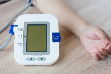 Woman using digital blood pressure monitor
