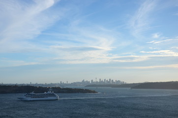 Obraz premium Sydney, Australia - March 30, 2013. Cruise ship navigating into the South Pacific Ocean. Harbour and CBD city view from North Head.