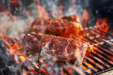 Gordijnen bbq varkensribbetjes koken op vlammende grill © Joshua Resnick