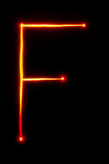 Obraz premium red light painting letter F on black background