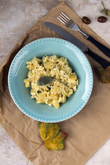 Risotto with patison and sage. Vegetarian dish, beige background and autumn leaves.