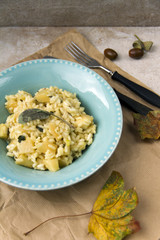 Risotto with patison and sage. Vegetarian dish, beige background and autumn leaves.