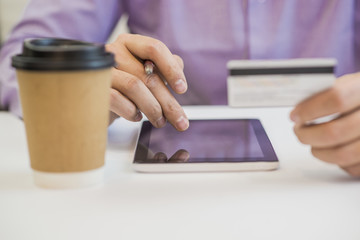 Businessman using a credit card and digital tablet for buying on line