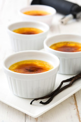 Traditional French creme brulee dessert with caramelized sugar on top, on wooden table

