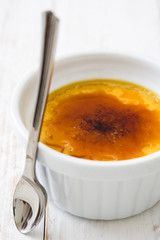 Traditional French creme brulee dessert with caramelized sugar on top, on wooden table


