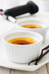 Traditional French creme brulee dessert with caramelized sugar on top, on wooden table

