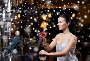 glamorous woman with cocktail at night club or bar