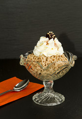 VERMICELLES SWISS DESSERT. CHESTNUT WITH CREAM IN GLASS CUP ON BLACK BACKGROUND