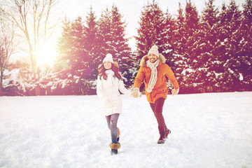 happy couple running in winter snow