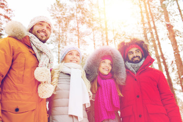 group of smiling men and women in winter forest