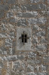 VENTANA CON UNA REJA DE METAL EN UNA PARED DE PIEDRA