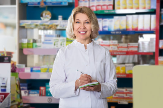Smiling female pharmacist posing in drugstore