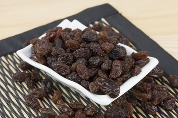 raisins in saucer on table.
