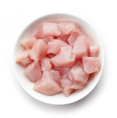 Raw cut chicken fillet in white bowl, from above