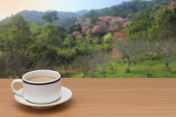 coffee on wooden table with nature background