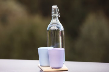 Flasche Wasser mit Becher