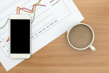 Office desk workplace with charts, coffee cup, and smartphone 