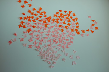 Paper pink rose and red butterflies in form of heart fly on a wall. Valentines day. 14 february