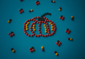 Symbol Halloween Holiday - a  yellow orange pumpkin made of small round candies. Isolated on a white background.