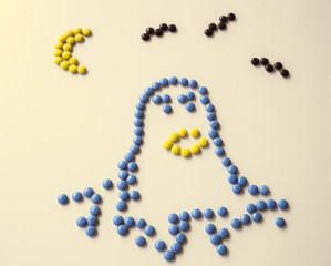 Halloween Holiday scary fly bat or flittermouse and moon and happy ghost face made of round small chocolate color candy. Isolate on white background.