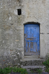 Fototapeta na wymiar An old wooden door in a derelict building the village of Oblizza, Friuli, north east Italy. 
