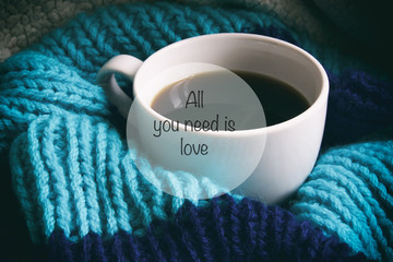 A cup of coffee, white cup in a scarf, the inscription on the pi