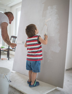 Little cute boy painting on a wall