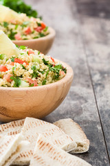Tabbouleh salad with couscous on rustic wooden table

