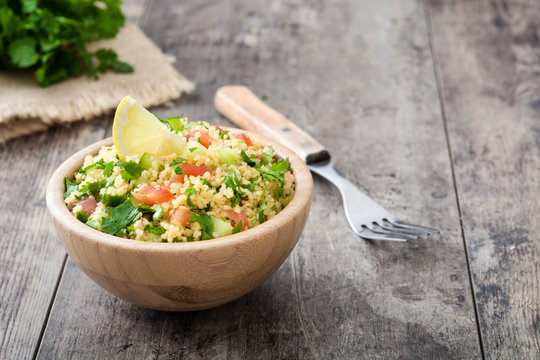 Tabbouleh salad with couscous on rustic wooden table

