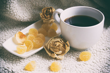 A cup of coffee, white cup and saucer white, fruit jelly on a pl