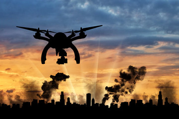 Silhouette flying reconnaissance drone over the city in smoke