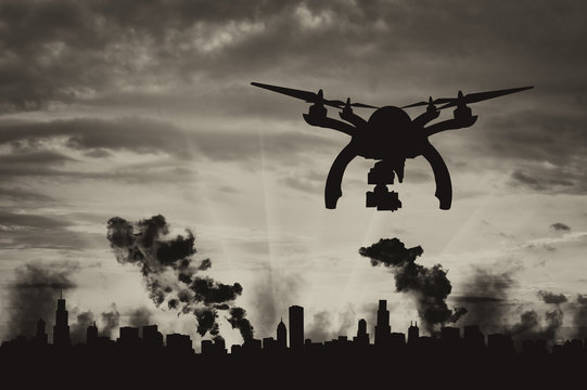 Silhouette flying reconnaissance drone over the city in smoke