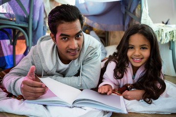 Father and daughter reading book