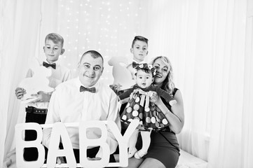 Caucasian family posed in vintage studio room with baby sign pla