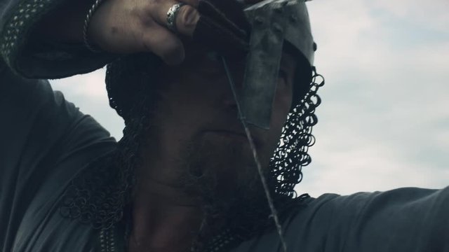 Medieval Archer Draws a Bowstring, Aims and Prepares to Shot. Medieval Reenactment. Shot on RED Cinema Camera in 4K (UHD).
