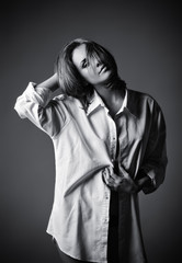 Studio shot of seductive young girl wearing white shirt. Black and white